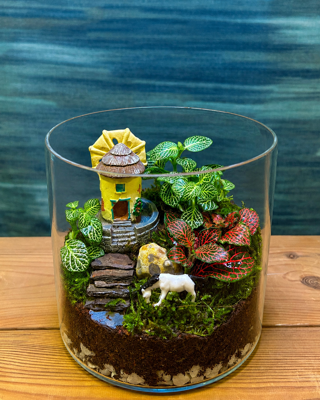 Glass Cottage Garden Terrarium with fittonia, a small cottage and white horse miniature from Planterie plant studio in Delhi, an inviting homely scene ideal as glass terrarium for gifting, tabletop plants for gifting and indoor plants for gifting for people who love storybook gardens