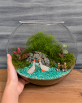 Ducks Lake Terrarium from Planterie, a miniature glass terrarium with tiny duck figurines, pebbles, moss and a small pond arrangement to look like a duck lake, shown with care tips for indoor display in Indian homes and offices