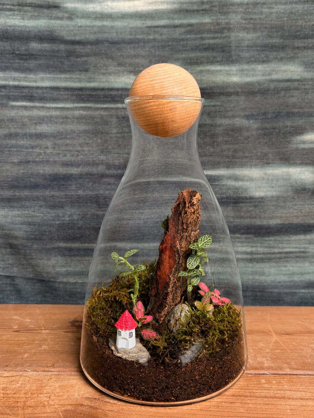 Forest Cottage Terrarium from Planterie, a handcrafted decanter glass terrarium featuring a charming cottage miniature and live plants in a cozy indoor desktop micro-garden, perfect as terrarium in Delhi for plant gifts in Delhi, desktop indoor plants and plant gifting near me Delhi.